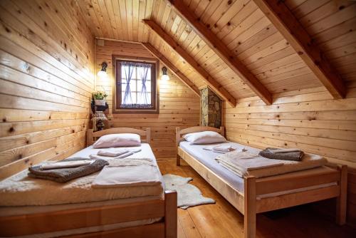 a room with two beds in a log cabin at Private Cabin in the Woods in Žabljak