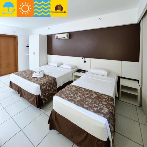 a hotel room with two beds in it at Suites Le Jardin Caldas Novas - Temporada in Caldas Novas