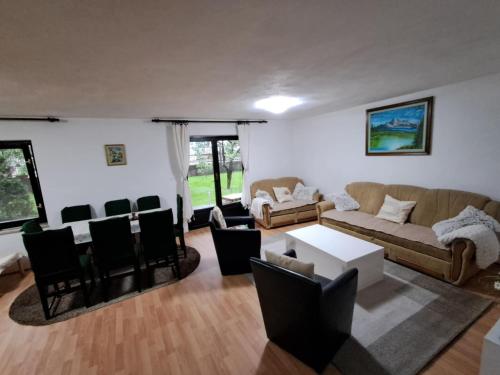 a living room with a couch and a table and chairs at Kuca za odmor Amber in Bihać