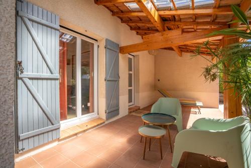 un patio avec des chaises, une table et une fenêtre dans l'établissement La Brise douce YourHostHelper, à Sète