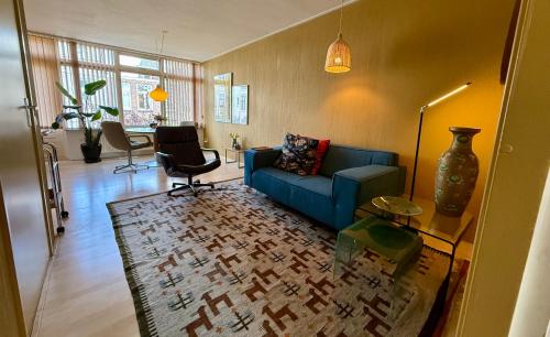a living room with a blue couch and a table at Japicx - Appartement in Leeuwarden
