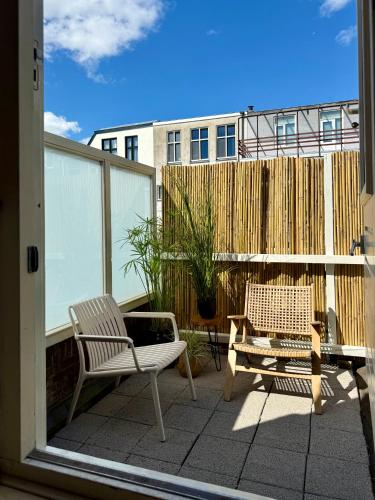 a patio with two chairs and a bench on a balcony at Japicx - Appartement in Leeuwarden