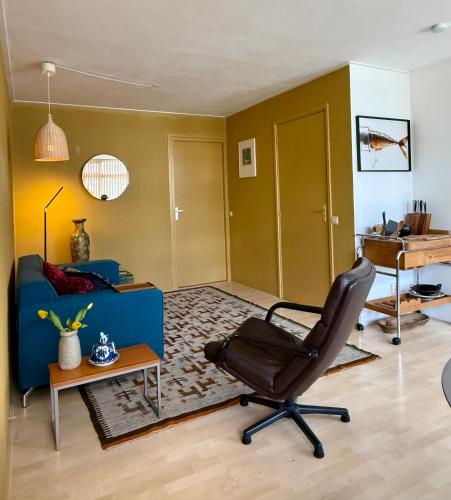a living room with a chair and a blue couch at Japicx - Appartement in Leeuwarden