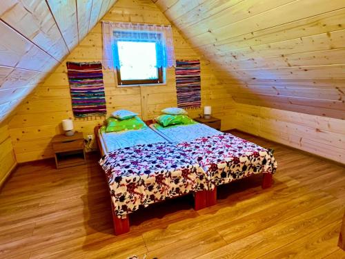 a bedroom with a bed in a log cabin at Siedlisko Jaskółka - Puszcza Białowieska in Białowieża