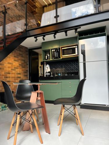 una cucina con armadi verdi e sedie nere di Loft Sonho de Beija ad Araxá