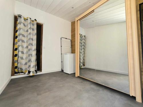 Cette chambre comprend un miroir et un réfrigérateur. dans l'établissement Villa des deux horizons, piscine, idéal famille, à Sorgues