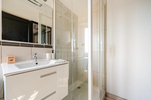 une salle de bain blanche avec un lavabo et une douche dans l'établissement Grasse B - Two rooms 4 people Downtown - AIR-CONDITIONING, à Grasse