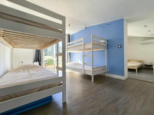 une chambre avec deux lits superposés et un mur bleu dans l'établissement Villa des deux horizons, piscine, idéal famille, à Sorgues