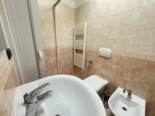 a bathroom with a white sink and a toilet at Pineta Apartament in Tirrenia