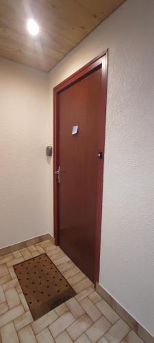 Cette chambre dispose de carrelage et d'une porte marron. dans l'établissement Les Flocons, aux Gets