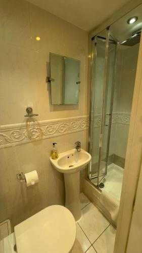 a bathroom with a toilet and a sink and a shower at Classic Hyde Park Hotel in London