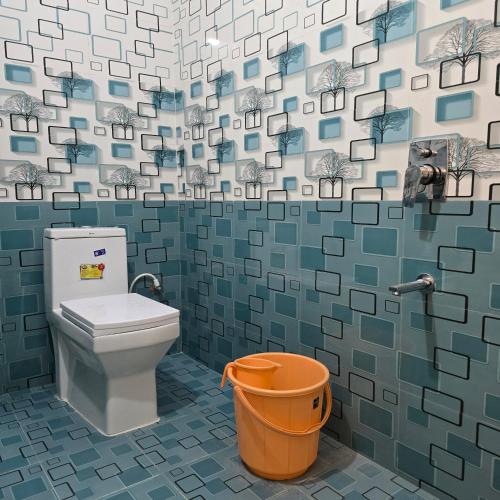 a bathroom with a toilet and a trash can at Padmini's home stay New apartment 2bhk in Tirupati