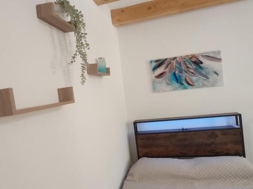 a bedroom with a bed and a picture on the wall at Central apartment with charm for 1 or 2 people - Casa Vacanze Luna in Lascari