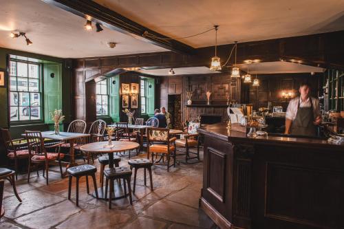 a woman standing at a bar in a restaurant at Bel and The Dragon-Odiham in Odiham