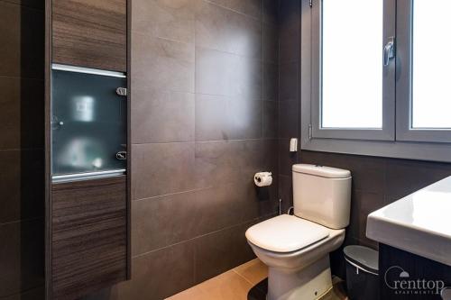 a bathroom with a white toilet and a sink at Rent Top Apartments Rambla Catalunya in Barcelona
