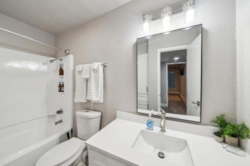 a bathroom with a sink and a toilet and a mirror at The Chandler 412 I Spacious 1 Bed 1 Bath in Grand Prairie