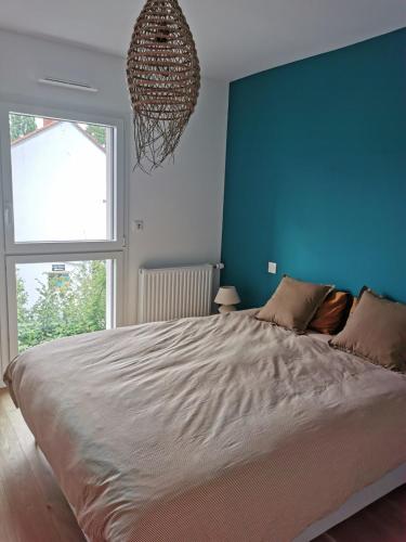 une chambre avec un grand lit avec un mur bleu dans l'établissement 2 room Apartment terrace near beach, à La Celle-sous-Gouzon