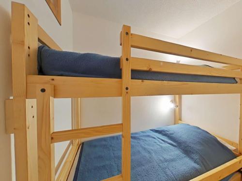 Ce lit superposé se trouve dans une petite chambre dotée de draps bleus. dans l'établissement Charmant appt 2 pièces, 6 pers, centre, animaux permis, ménage inclus - FR-1-241-111, au Grand-Bornand
