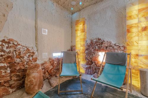 two chairs in a room with a stone fireplace at Lazurowy Dwór by Grand Apartments - jacuzzi, sauna i wiele innych atrakcji w budynku in Sztutowo