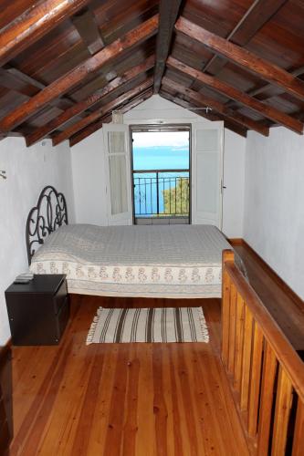 ein Schlafzimmer mit einem Bett in einem Zimmer mit Fenster in der Unterkunft Sunset House in Klíma