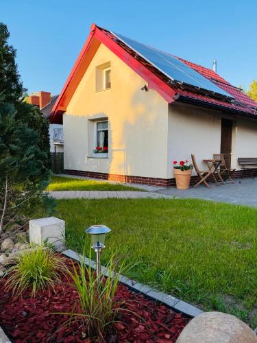 una casa amarilla y blanca con techo rojo en Noclegi u Justyny, en Łagów