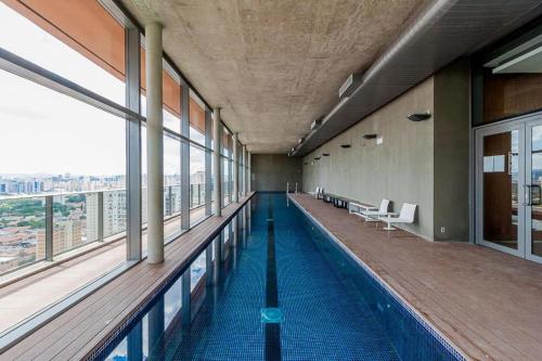 a swimming pool in a building with windows at Magníficos Ap Luxo - 43mts e 63mts, 1 ou 2 Qtos in São Paulo