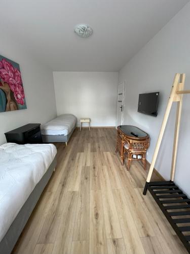 a bedroom with a bed and a desk and a tv at SasApartamenty in Milanówek