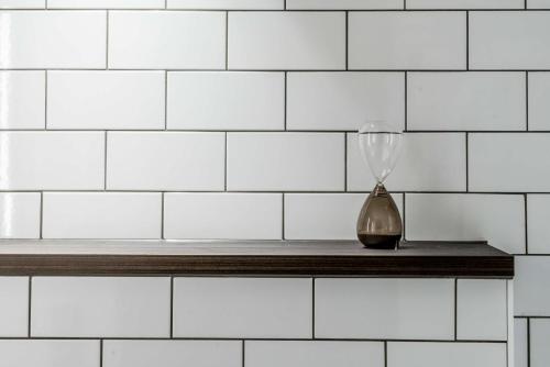 a vase sitting on a shelf in a white tiled wall at Downtown Camper by Scandic in Stockholm