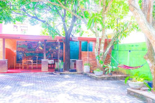 a house with a tree and a patio with plants at Liyasha Hotel in Anuradhapura