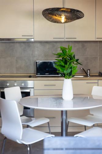 a kitchen with a table and white chairs at Full Sea View Penthouse with Panoramic terrace in Prčanj
