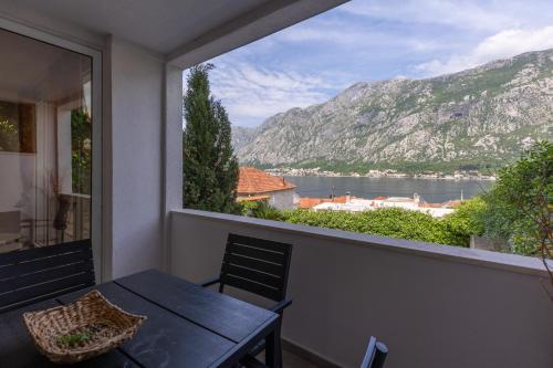 a balcony with a table and a view of the water at Full Sea View Penthouse with Panoramic terrace in Prčanj