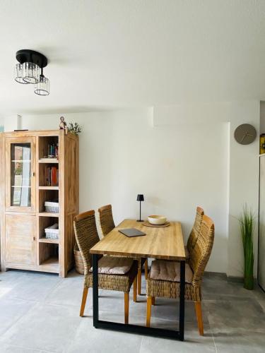 une salle à manger avec une table et des chaises en bois dans l'établissement Maison Lagune bleu, à Gruissan