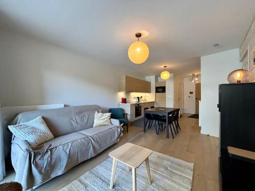 un salon avec un canapé et une table dans l'établissement Homency - Résidence Fermes de l'Alpe D101, à L'Alpe-d'Huez