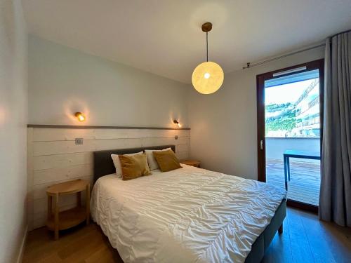 une chambre avec un grand lit et une fenêtre dans l'établissement Homency - Résidence Fermes de l'Alpe D101, à L'Alpe-d'Huez