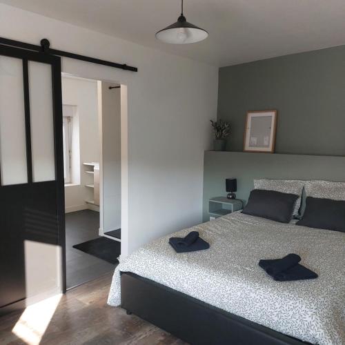 - une chambre avec un lit doté de deux chapeaux noirs dans l'établissement Le refuge du lac, à La Tessoualle