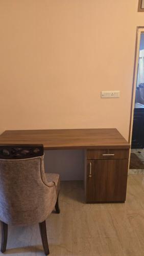 a wooden desk with a chair next to a mirror at Cozy apartment in jodhpur park, kolkata in Kolkata
