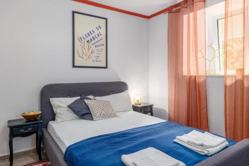 a bedroom with a bed with blue sheets and a window at Full Sea View Penthouse with Panoramic terrace in Prčanj