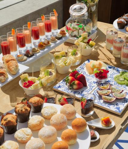 a table topped with plates of food and pastries at H10 Duque de Loule in Lisbon