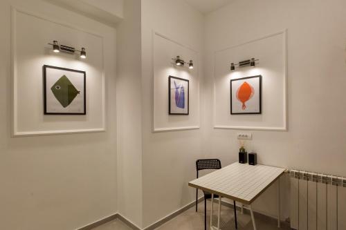 a room with a table and some pictures on the wall at High Note Suites in Belgrade