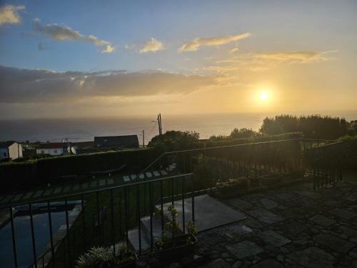 a view of the sunset from the balcony of a house at Casa do Castanheiro - Nordeste, Açores in Nordeste
