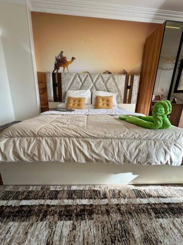 a bedroom with a large bed with a green dinosaur on it at Luxury Panorama pyramids & jacuzzi in Cairo