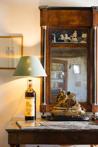 a bottle of wine and a lamp on a table at Villa Il Fedino in San Casciano in Val di Pesa