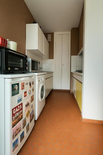 une cuisine avec un lave-linge et un micro-ondes dans l'établissement Appartement hyper centre avec Garage privé, au Mans