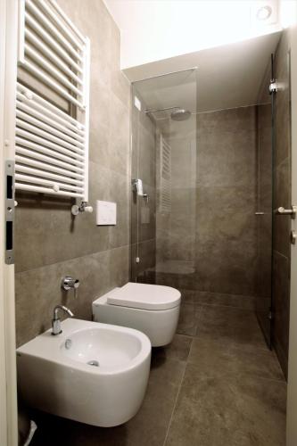 a bathroom with a white toilet and a sink at Hotel Oasi Verde in Bienno