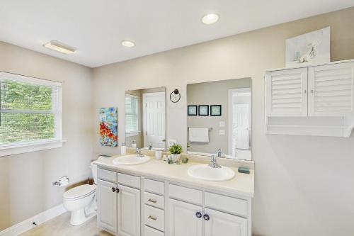 a white bathroom with two sinks and a toilet at Wet Feet Retreat in Moneta