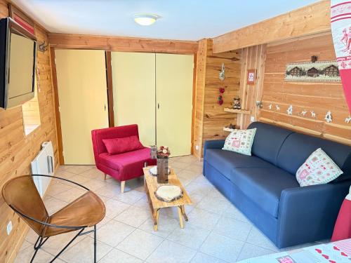 a living room with a blue couch and a red chair at Appartement dans Chalet avec Jardin in Barcelonnette