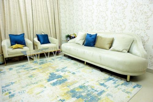 a living room with a white couch and blue pillows at entire 1BHK with Free parking and WIFI in the heart of Ajman City only for Families in Ajman 