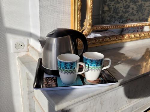 une théière et deux tasses sur un plateau sur une étagère dans l'établissement Grande Maison De MUREL, à Martel