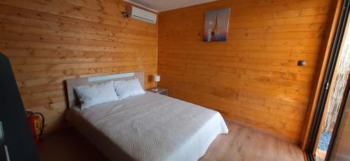 a bedroom with a bed in a wooden wall at Бунгало Шангри Ла-3, плаж Градина in Sozopol