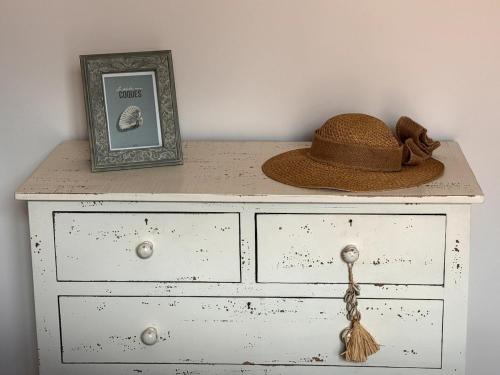 a hat and a picture on top of a dresser at Villa Manolita Andernos les Bains avec jaccuzi in Andernos-les-Bains